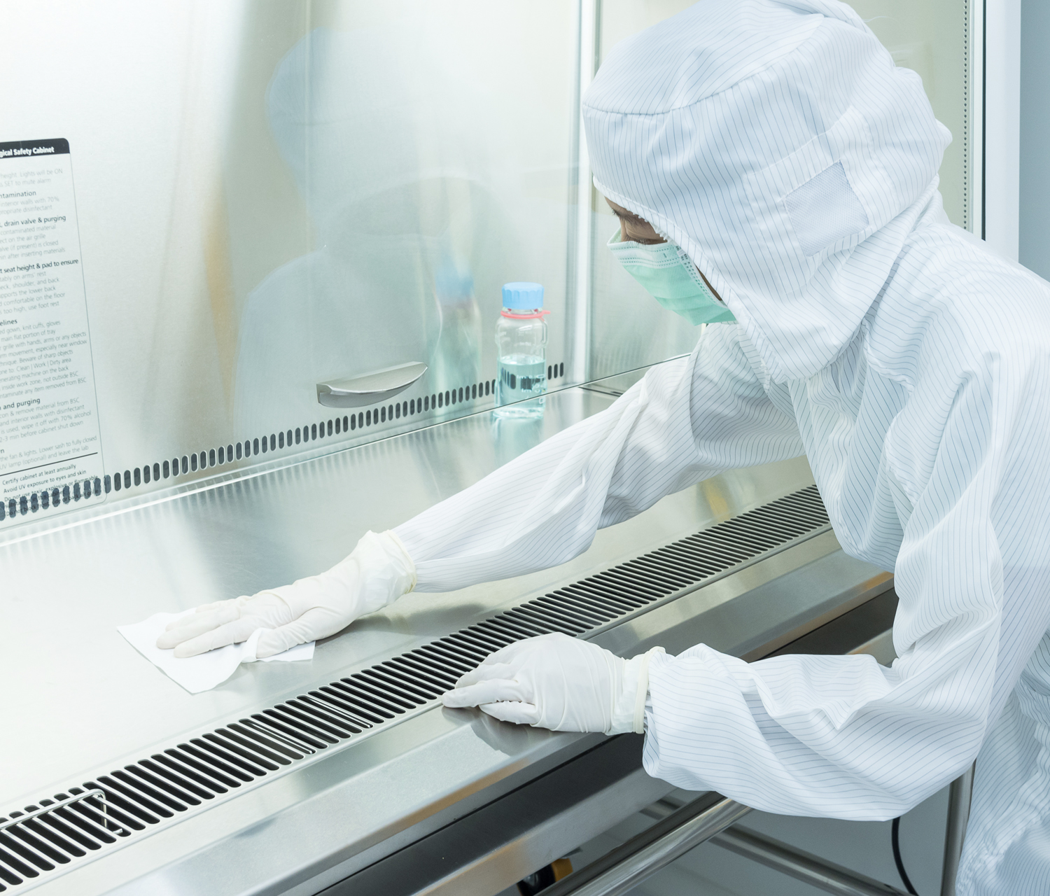 Woman wiping down a biological safety cabinet